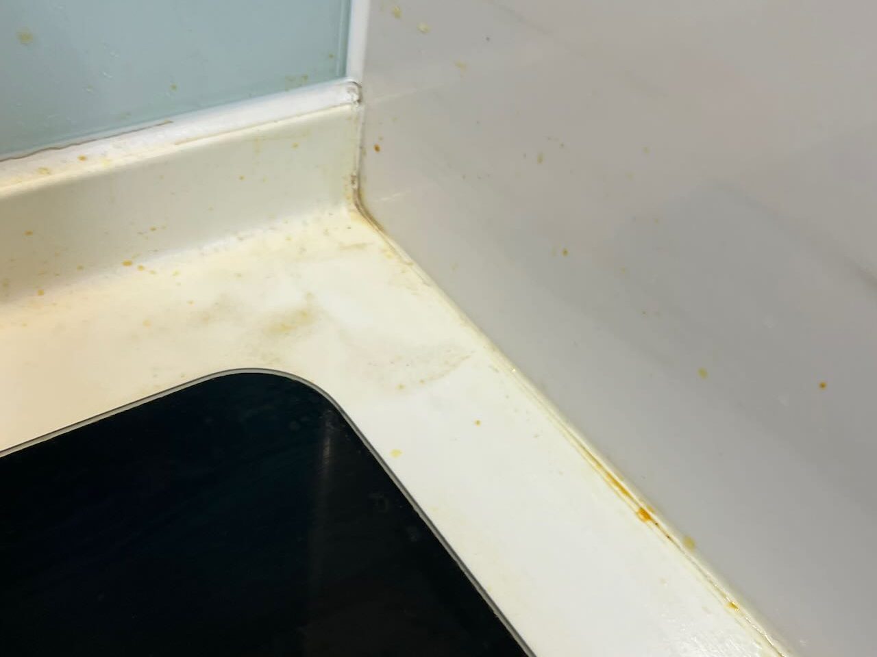 平鎮區廚房檯面轉角清潔前，邊緣有黃褐色油漬