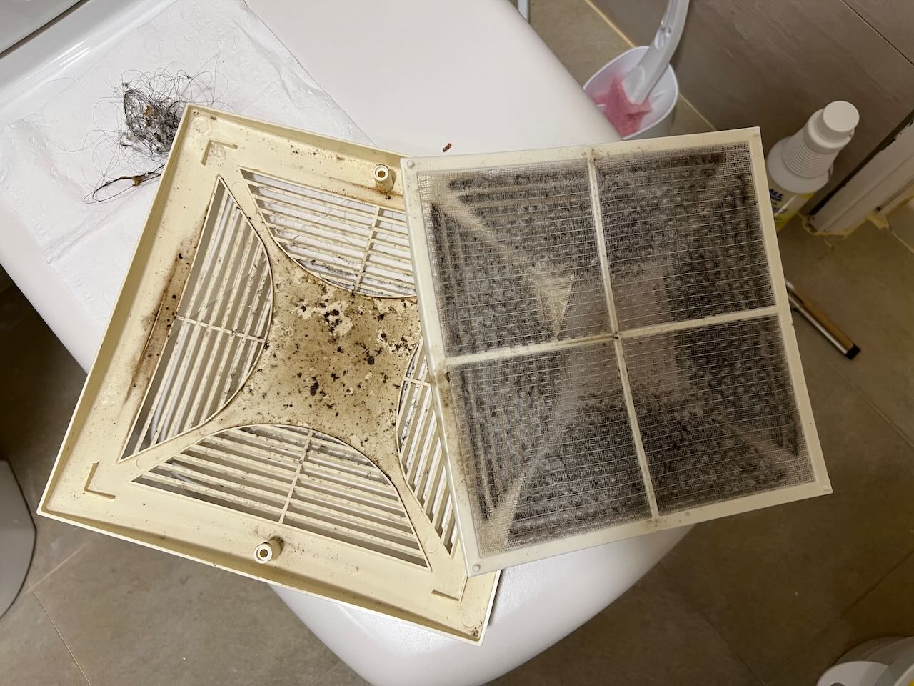 浴室排風扇濾網清潔前，佈滿黑色霉斑與灰塵